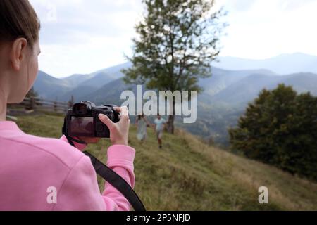 Professioneller Fotograf, der ein Paar in den Bergen fotografiert, Nahaufnahme Stockfoto