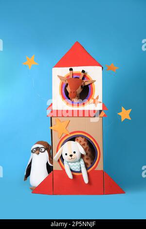 Papprakete und verschiedene Spielzeuge auf hellblauem Hintergrund Stockfoto