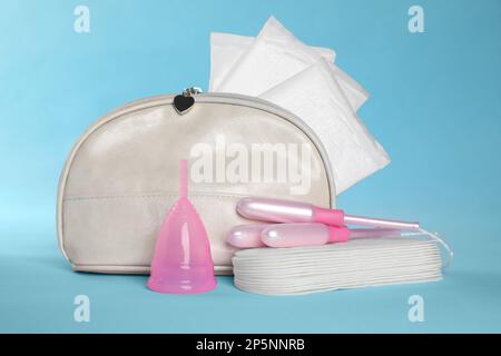 Beutel mit Menstruationseinlagen und anderen Hygieneprodukten auf hellblauem Hintergrund Stockfoto