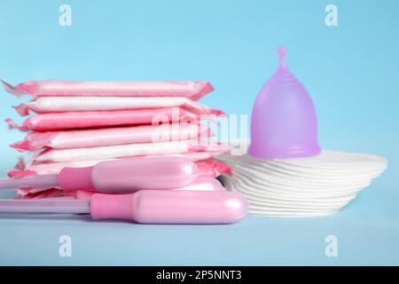 Menstruationseinlagen und andere Hygieneprodukte auf hellblauem Hintergrund, Nahaufnahme Stockfoto
