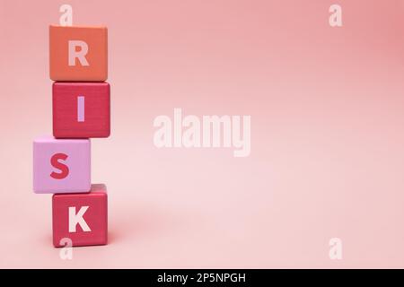 Stapel farbiger Holzwürfel mit Wortrisiko auf hellgrauem Hintergrund. Platz für Text Stockfoto