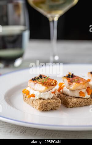 Rote Meerbarbe mit Strauchsauce auf Brotscheiben im Feinschmeckerrestaurant Stockfoto