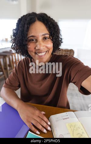 Glückliche, birassische Frau mit Videoanruf Stockfoto