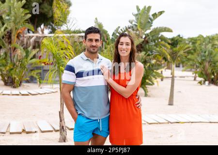 Porträt eines glücklichen birassischen Paares, das am Strand lächelt Stockfoto