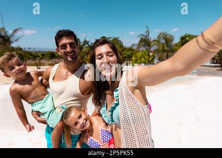 Glückliche birassische Familie, die Selfie am Strand macht Stockfoto