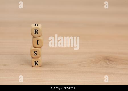 Stapel von Würfeln mit Wortrisiko auf Holztisch. Platz für Text Stockfoto