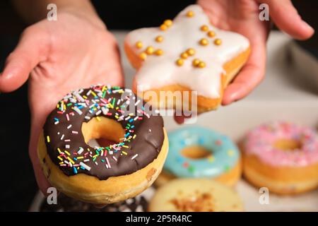 Zwei Donuts in der Hand einer Frau Stockfoto