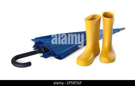 Gelbe Gummistiefel und blauer Regenschirm auf weißem Hintergrund Stockfoto