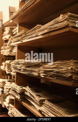 Sammlung alter Zeitungen auf Regalen in der Bibliothek Stockfoto