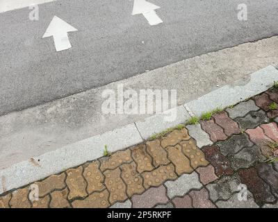 Bürgersteig und Struktur der Asphaltstraße mit Pfeil Stockfoto