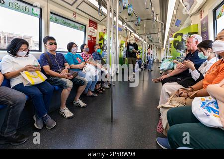 Ausländische und thailändische Passagiere, die mit der BTS Skytrain Elevated Railway, Bangkok, Thailand reisen Stockfoto