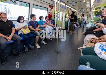 Ausländische und thailändische Passagiere, die mit der BTS Skytrain Elevated Railway, Bangkok, Thailand reisen Stockfoto