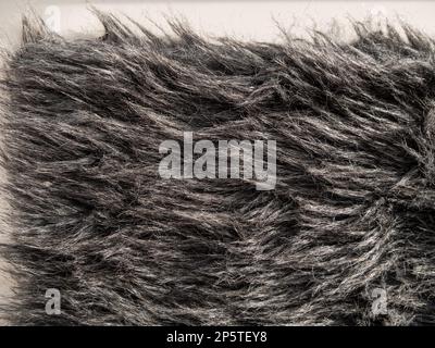 Langer grauer Überzug aus unechtem Pelz. Kunstfaser, weiches Kunstfell, Makromaterial, Foto. Einfarbige flauschige Oberfläche für digitale Papiergestaltung Winter CL Stockfoto