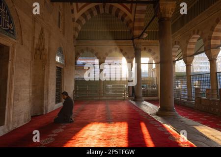 Islamisches Foto. Muslimischer Mann betet in der Moschee. Sonne und Dunst bei Sonnenuntergang. Hintergrundbild aus Ramadan oder islamic. Istanbul Turkiye - 12.24.2022 Stockfoto