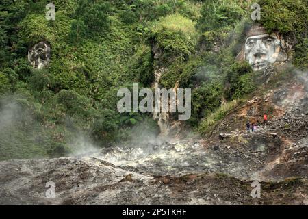 Fumarole Felder unterhalb der Seite eines Hügels, wo die riesigen Gesichter, die Toar und Lumimuut - die Ahnen der Minahasaner - darstellen, auf Bukit Kasih (Hügel der Liebe) geformt werden, einem beliebten religiösen Reiseziel im Dorf Kanonang, West Kawangkoan, Minahasa, North Sulawesi, Indonesien. Auf dem Hügel befindet sich ein ebener Boden, auf dem Gotteshäuser aller anerkannten Religionen in Indonesien gebaut werden. Bukit Kasih wurde Anfang des Jahrtausends gegründet und ist allen Gläubigen und Gläubigen gewidmet, während sie die Geister der Liebe, des Friedens und der Toleranz förderte. Stockfoto