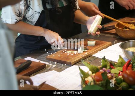 Erwachsene Schüler lernen das Rezept und bereiten das Essen im Kochkurs zu Stockfoto