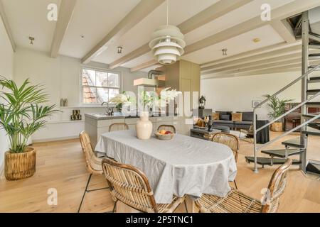 Ein Wohnzimmer mit Holzfußboden und weißen Wänden, es gibt eine offene Treppe, die in die zweite Etage führt Stockfoto