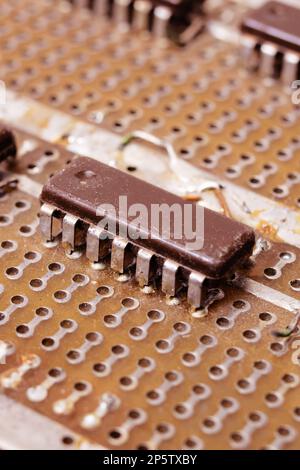 Alte schmutzige gelbe Leiterplatte mit Transistoren nah beieinander Stockfoto