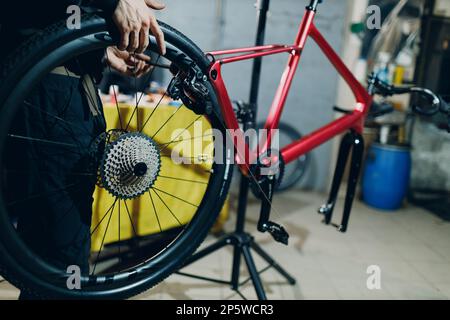 Mechaniker, der das Zahnrad-Kettenrad-Getriebe in der Werkstatt zusammenbaut Stockfoto