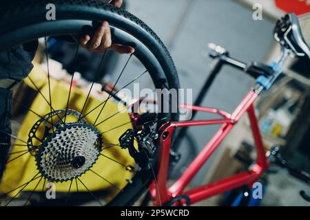 Mechaniker, der das Zahnrad-Kettenrad-Getriebe in der Werkstatt zusammenbaut Stockfoto