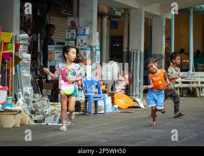 Zwei junge Mädchen und ein Junge Rennen und spielen auf dem Central Market in Phnom Penh, Kambodscha. Stockfoto