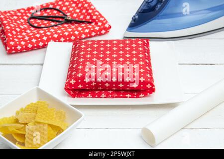 Sandwich zum Mitnehmen in hausgemachtem Bienenwachs. Umwickeln von Lebensmitteln in handgemachtes Bienenwachs-Wickeltuch im Innenbereich, Alternative zu Kunststoff. Stockfoto