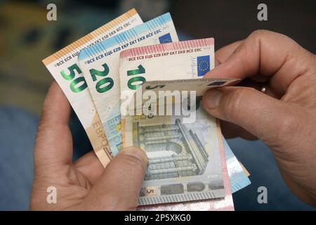 Der Mann zählt den Rest seiner Ersparnisse Stockfoto