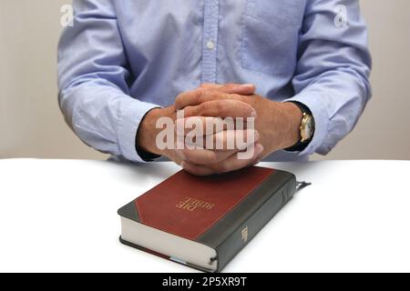 Gefaltete Hände für einen Mann in einer bibel Stockfoto