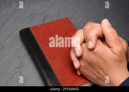 Gefaltete Hände an einer bibel Stockfoto