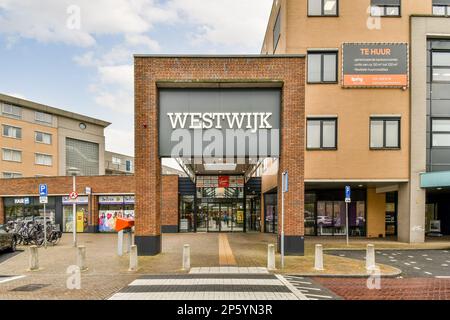 Der Eingang zum Westwick Einkaufszentrum, mit Autos vor dem Hotel und Leuten, die auf der Straße dahinter laufen Stockfoto