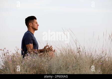 Mann meditiert auf dem Hügel, Platz für Text Stockfoto