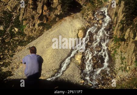 Tripper und Wasserfall, in der Nähe des Obago-Sees, Colomèrs cirque, Aran Valley, Aigüestortes und Estany de Sant Maurici National Park, Pyrenäen, Lleida Prov Stockfoto