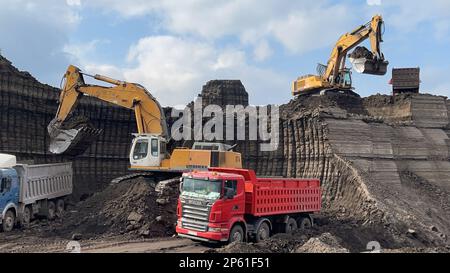 Hydraulikbagger, Die Auf Großen Bergbaustellen Arbeiten, Lkw Beladen, Lkw Transportieren Das Material. Stockfoto