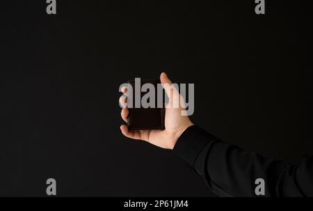 Brauner, leerer, handgemachter Lederkartenhalter in der Hand eines Mannes. Stockfoto