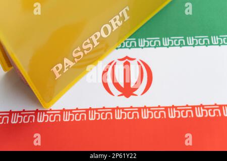 iranische Flagge mit Reisepass. Reisevisum und Staatsbürgerschaftskonzept. Aufenthaltstitel im Land. Ein gelbes Dokument mit der Inschrift Reisepass ist o Stockfoto