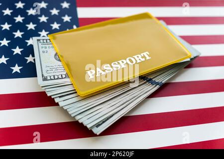 US-amerikanischer Pass und Geld-Dollar auf Flaggenhintergrund. Stockfoto