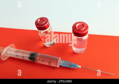 Impfungen in Polen. Impfstoff zum Schutz gegen Covid-19 vor dem Hintergrund der Nationalflagge. Stockfoto