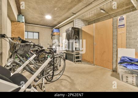 Amsterdam, Niederlande - 10. April 2021: Einige Fahrräder in einem Raum, der als Lagerbereich für andere Gegenstände und Geräte an der Wand genutzt wird Stockfoto