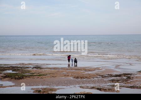 Ein Familienspaziergang an einem Sandstrand in Bexhill, Großbritannien. Stockfoto