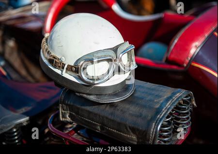 Vintage Crashhelm und Schutzbrille auf Motorradsitz Stockfoto