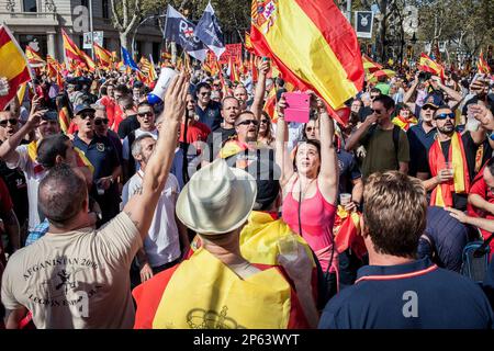 Katalanische Demonstranten gegen die Unabhängigkeit tragen spanische Flaggen während einer Demonstration für die Einheit Spaniens anlässlich des Spanischen Nationalfeiertags Stockfoto