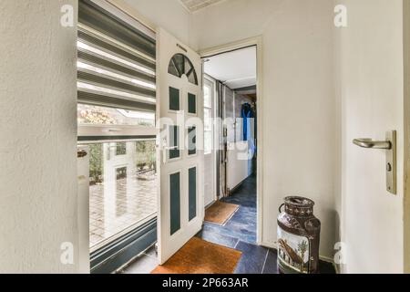 Das Innere eines Hauses, das aussieht, als würde es durch eine offene Tür zu einem anderen Raum im Haus gehen Stockfoto