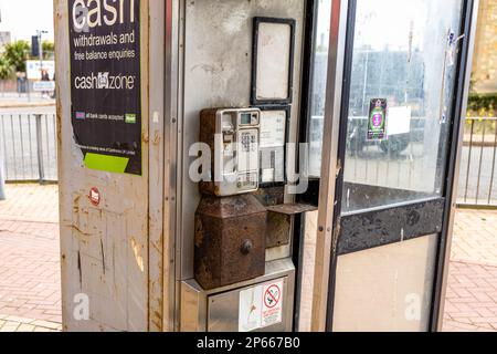 Dreckige, alte, münzbetriebene Telefonzelle, rostig und unbenutzt Stockfoto