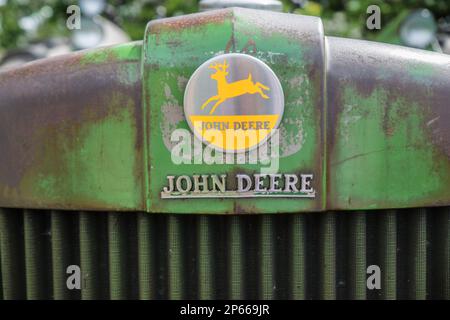 Chrome-Emblem und -Logo auf der Vorderseite eines klassischen John Deere Traktors Stockfoto