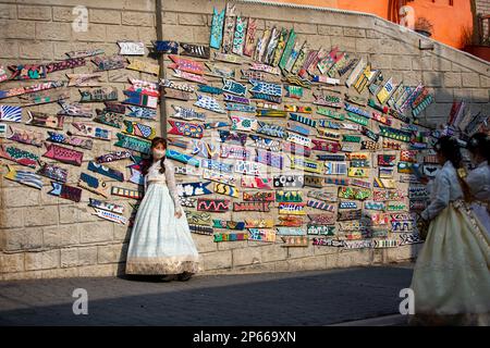 BUSAN, 7. März 2023 (Xinhua) – Ein Tourist posiert für ein Foto mit Dekorationen an einer Wand im Gamcheon Culture Village in Busan, Südkorea, 7. März 2023. Das an den Ausläufern eines Küstenbergs in Busan gelegene Gamcheon Culture Village ist berühmt für seine Treppenhäuser und Gassen, die mit Wandgemälden und Skulpturen geschmückt sind. (Xinhua/Wang Yiliang) Stockfoto
