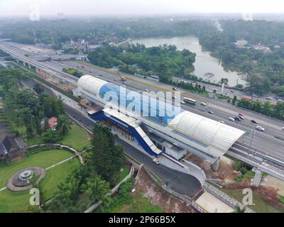 Luftaufnahme einer im Bau befindlichen LRT-Station, über der Schnellstraße und neben einem Park. Stockfoto