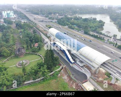 Luftaufnahme einer im Bau befindlichen LRT-Station, über der Schnellstraße und neben einem Park. Stockfoto