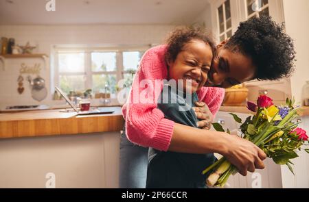 Mutter mit Blumenstrauß und küssendem Sohn am Muttertag Stockfoto