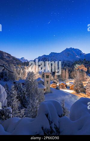 Chiesa Bianca bedeckt mit Schnee unter einem hellen Sternenhimmel zu Weihnachten, Maloja, Bregaglia, Engadine, Kanton Graubunden, Schweiz, Europa Stockfoto