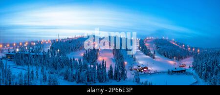 Winterdämmerung über den schneebedeckten Skipisten des Ruka Tourist Resort, Luftaufnahme, Kuusamo, Nordöstrobothnia, Lappland, Finnland, Europa Stockfoto